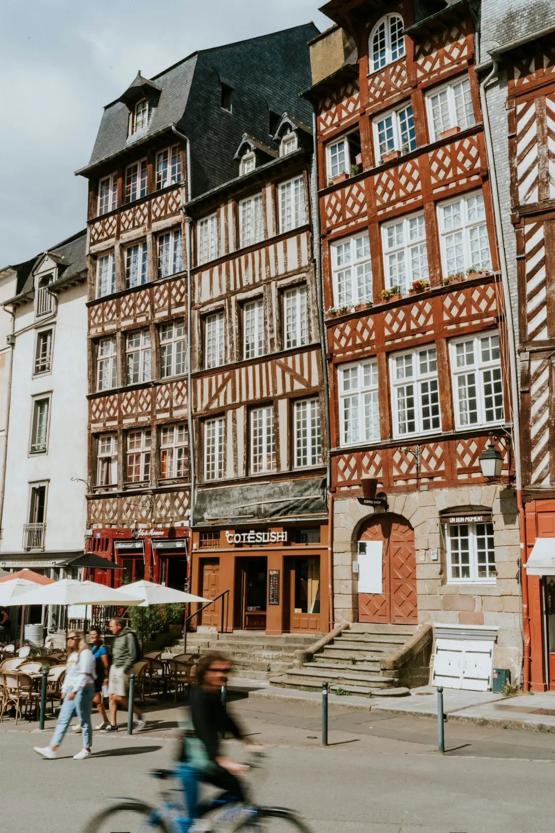 Conciergerie Airbnb Rennes — questions fréquentes Une rue du centre de Rennes à vélo